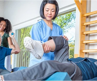 Image for a news release of an allied health professional helping someone stretch.