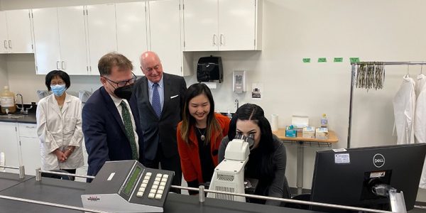 Adrian Dix news release with someone looking into microscope